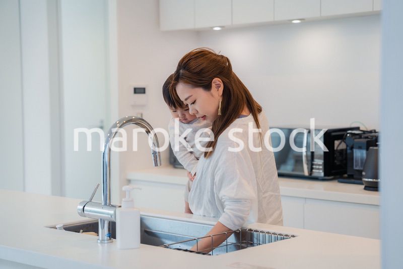 赤ちゃんを抱っこしながら家事をするお母さん