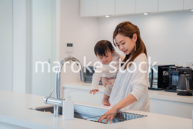 赤ちゃんを抱っこしながら家事をするお母さん