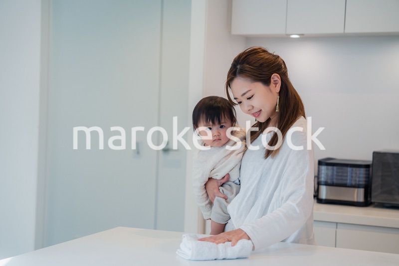 赤ちゃんを抱っこしながら家事をするお母さん