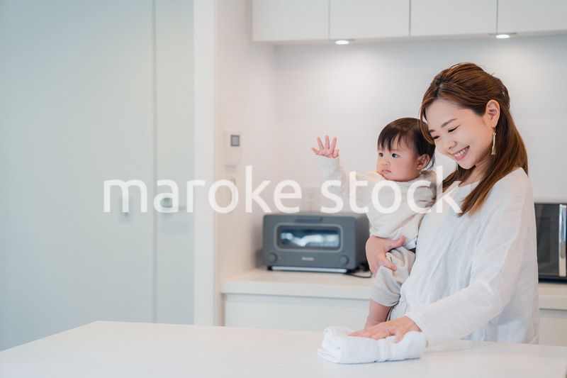 赤ちゃんを抱っこしながら家事をするお母さん