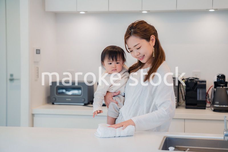 赤ちゃんを抱っこしながら家事をするお母さん