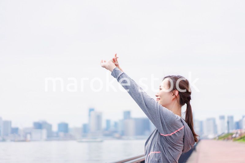 スポーツウェアで深呼吸をする若い女性