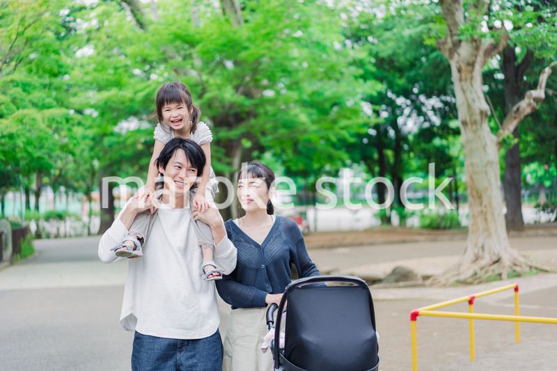 子供と一緒に公園を散歩する家族
