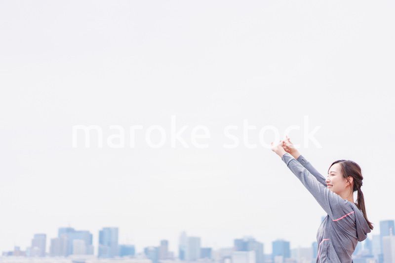 スポーツウェアで深呼吸をする若い女性