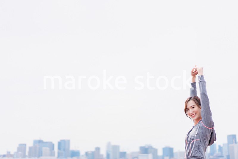 スポーツウェアで深呼吸をする若い女性