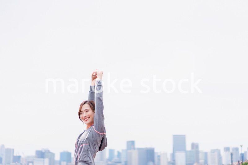 スポーツウェアで深呼吸をする若い女性