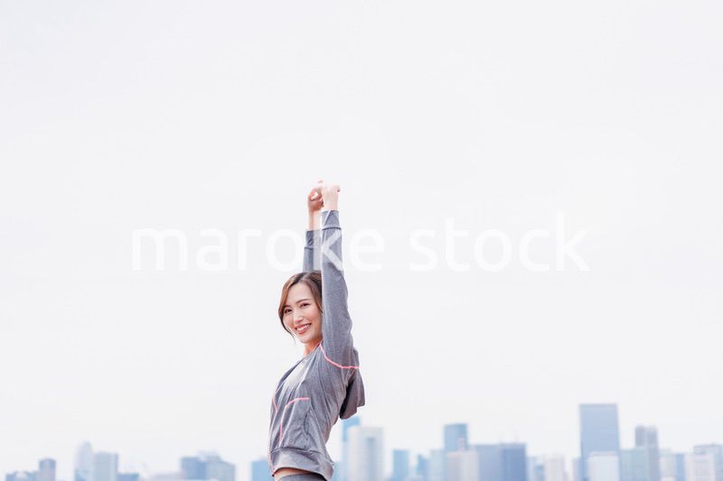 スポーツウェアで深呼吸をする若い女性