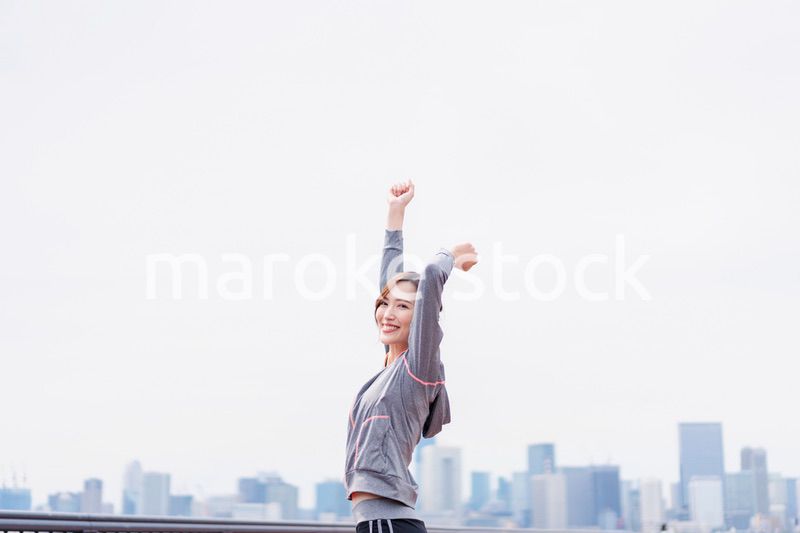 スポーツウェアで深呼吸をする若い女性