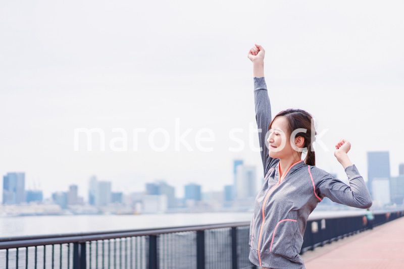 スポーツウェアで深呼吸をする若い女性