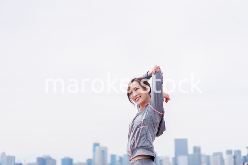 屋外でストレッチをする若い女性