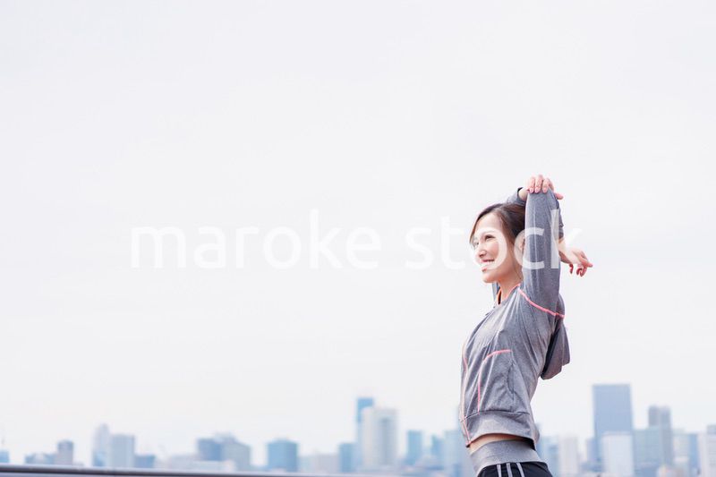 屋外でストレッチをする若い女性