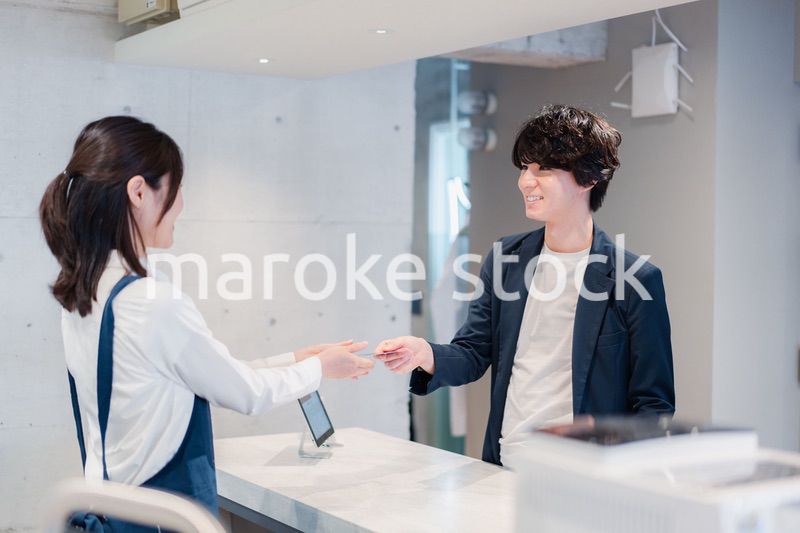 カフェでクレジットカード決済をする男性