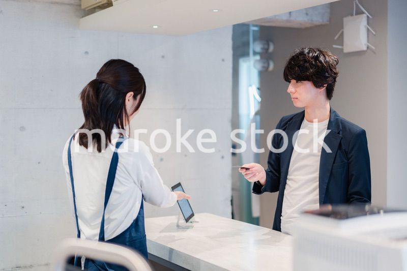 カフェでクレジットカード決済をする男性