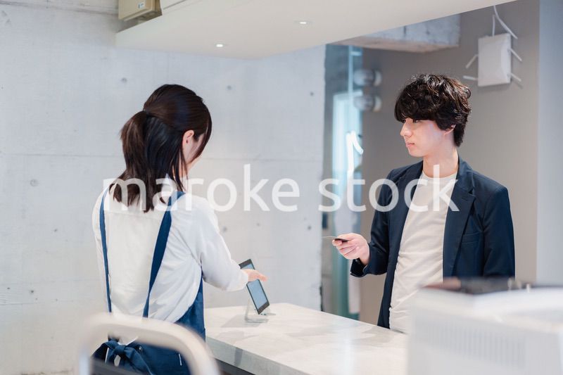 カフェでクレジットカード決済をする男性