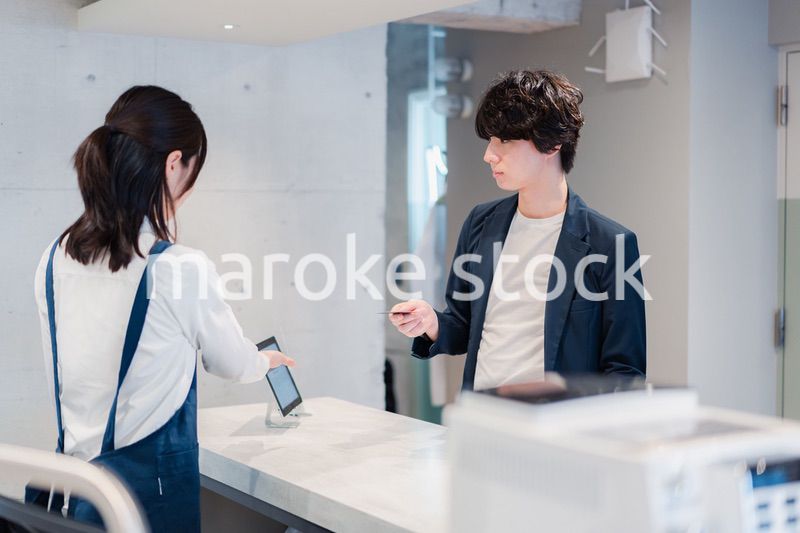 カフェでクレジットカード決済をする男性