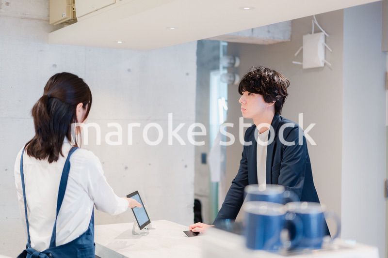 カフェでクレジットカード決済をする男性