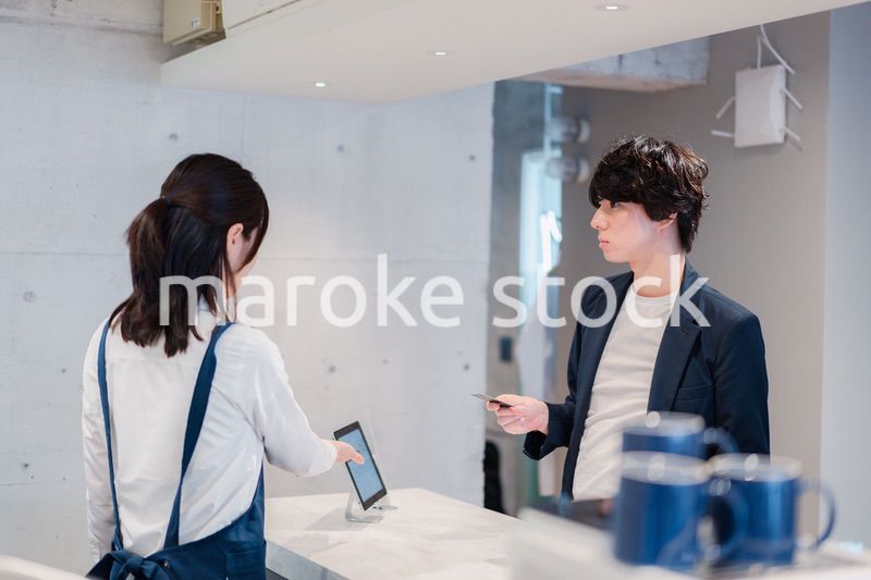 カフェでクレジットカード決済をする男性