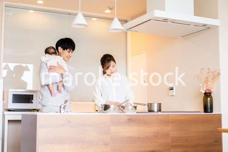 キッチンで料理をするお母さんとお父さんと赤ちゃん