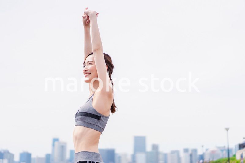 スポーツウェアで深呼吸をする若い女性