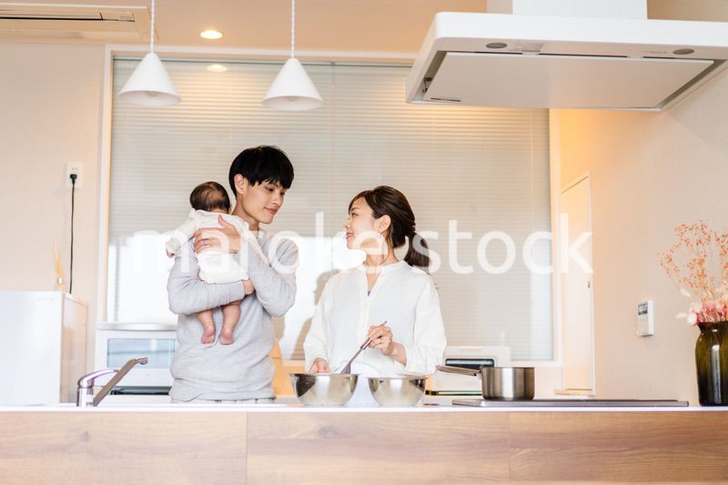 キッチンで料理をするお母さんとお父さんと赤ちゃん