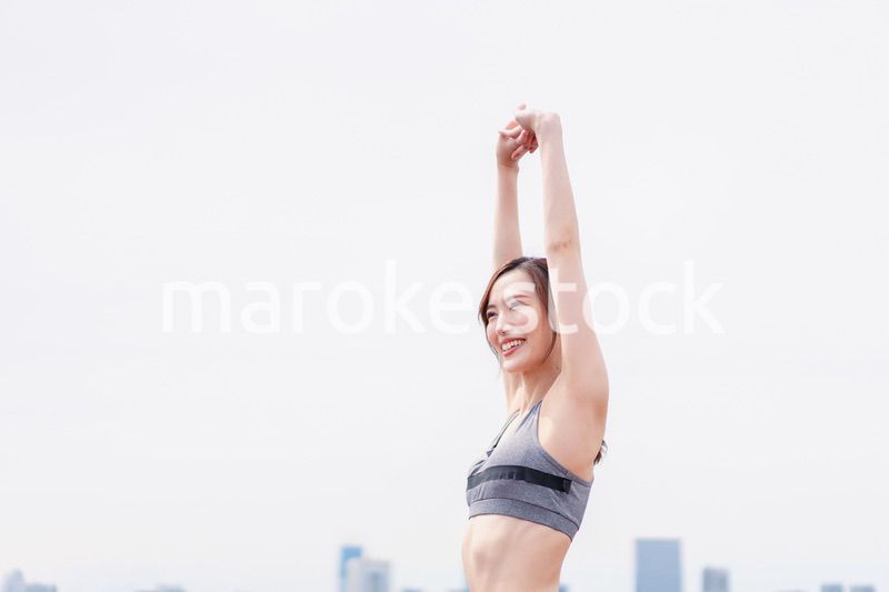 スポーツウェアで深呼吸をする若い女性