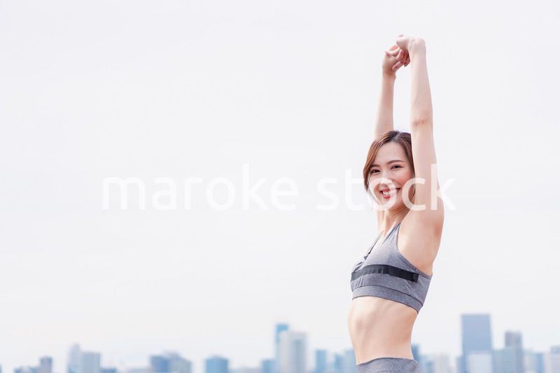 スポーツウェアで深呼吸をする若い女性