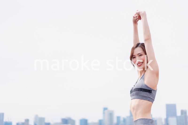 スポーツウェアで深呼吸をする若い女性