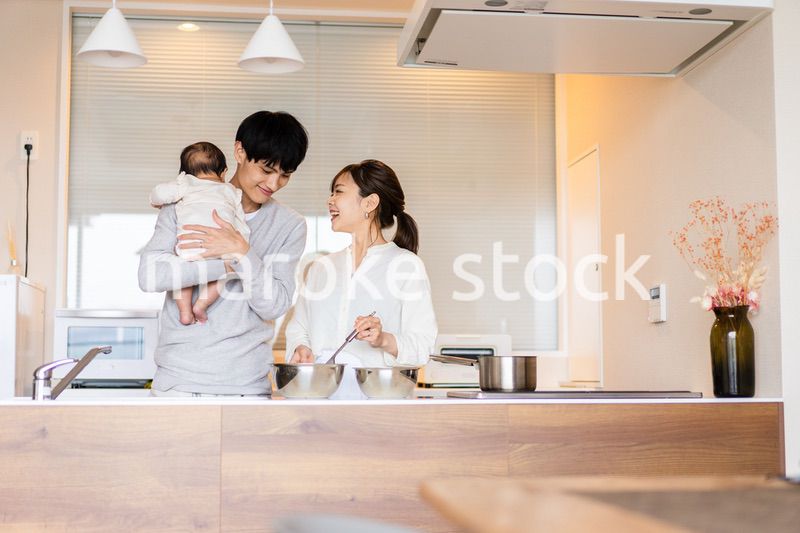キッチンで料理をするお母さんとお父さんと赤ちゃん