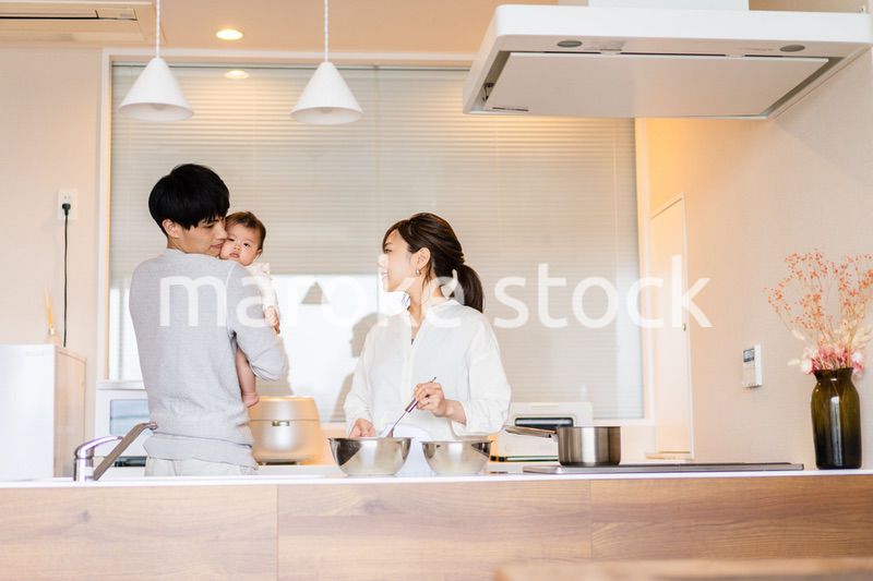 キッチンで料理をするお母さんとお父さんと赤ちゃん