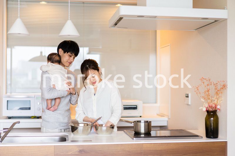 キッチンで料理をするお母さんとお父さんと赤ちゃん