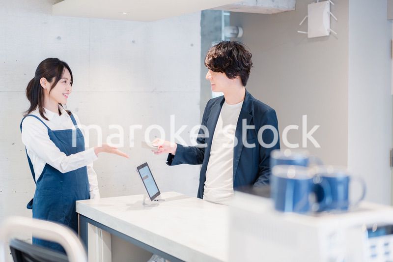 カフェでクレジットカード決済をする男性