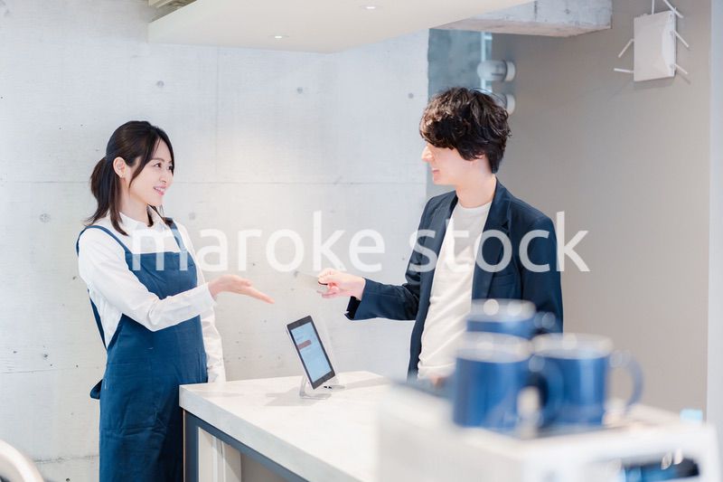 カフェでクレジットカード決済をする男性