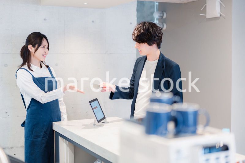 カフェでクレジットカード決済をする男性