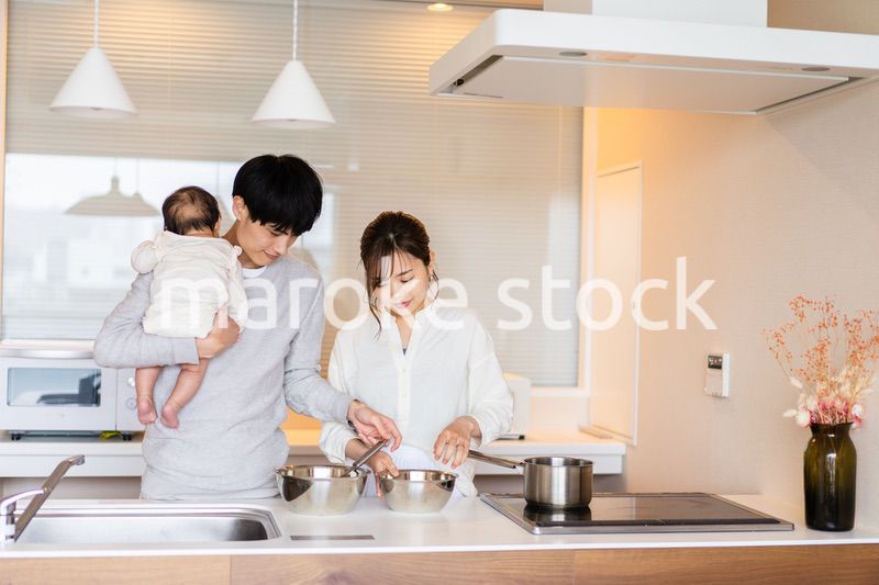 キッチンで料理をするお母さんとお父さんと赤ちゃん