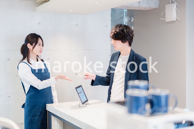 カフェでクレジットカード決済をする男性