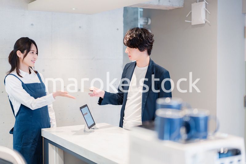 カフェでクレジットカード決済をする男性