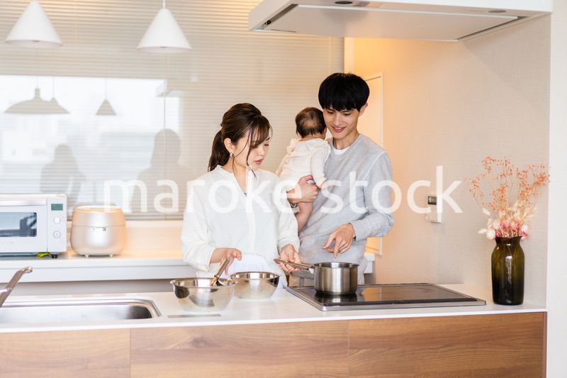 キッチンで料理をするお母さんとお父さんと赤ちゃん