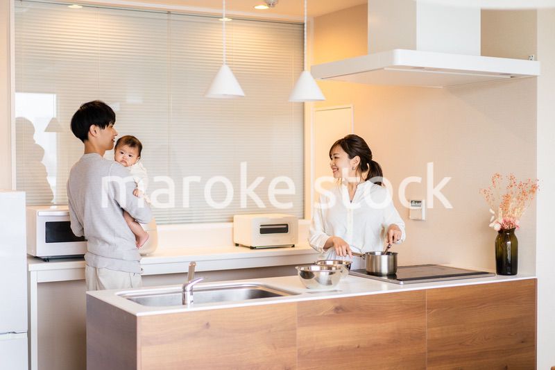 キッチンで料理をするお母さんとお父さんと赤ちゃん