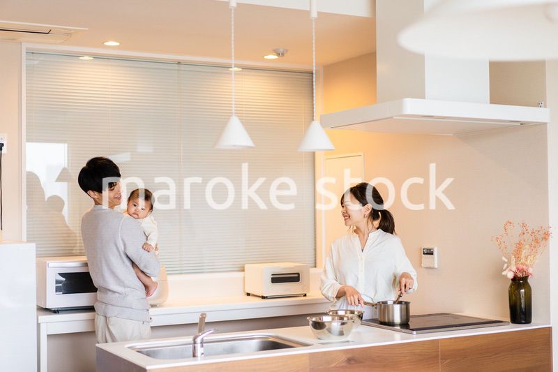 キッチンで料理をするお母さんとお父さんと赤ちゃん