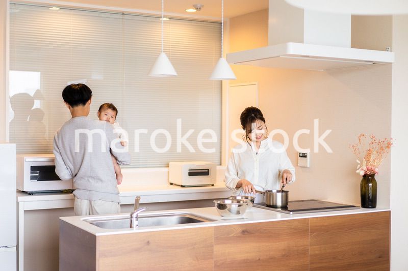キッチンで料理をするお母さんとお父さんと赤ちゃん