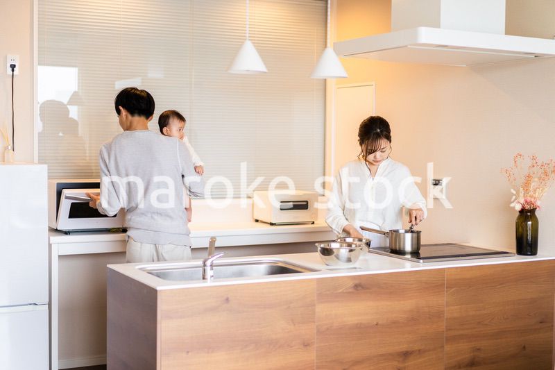 キッチンで料理をするお母さんとお父さんと赤ちゃん