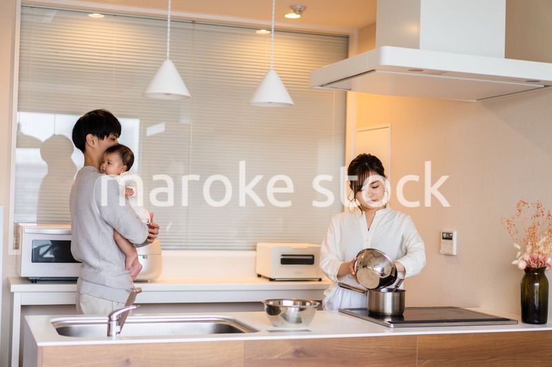キッチンで料理をするお母さんとお父さんと赤ちゃん