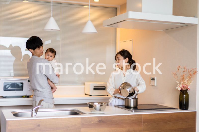 キッチンで料理をするお母さんとお父さんと赤ちゃん