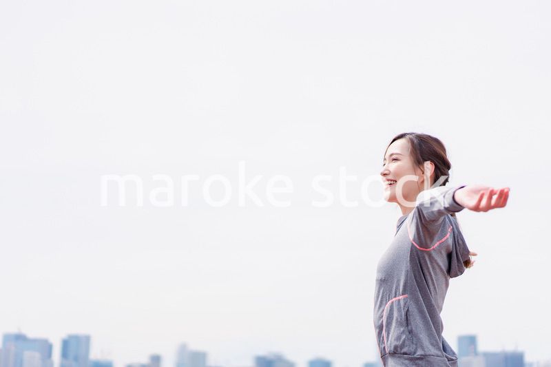 スポーツウェアで深呼吸をする若い女性