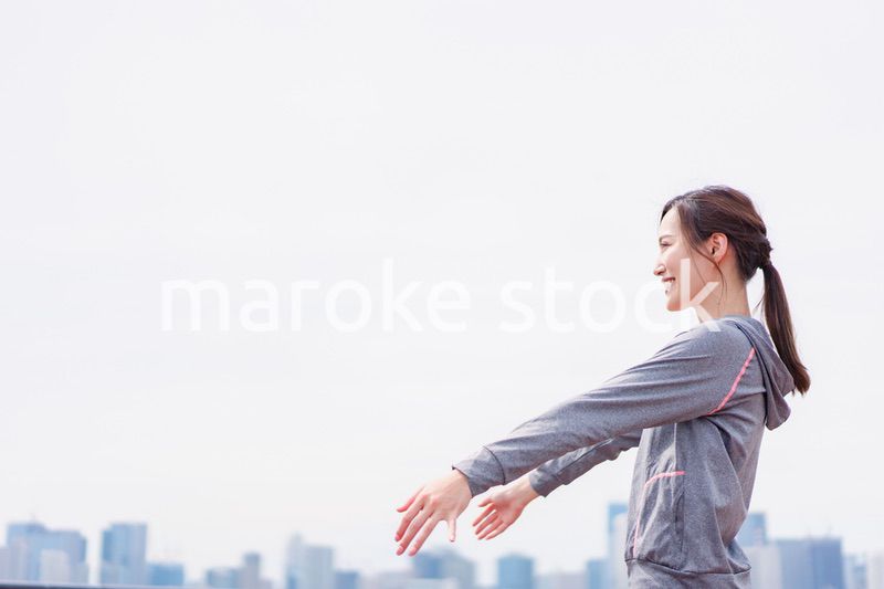 スポーツウェアで深呼吸をする若い女性