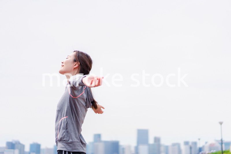 スポーツウェアで深呼吸をする若い女性