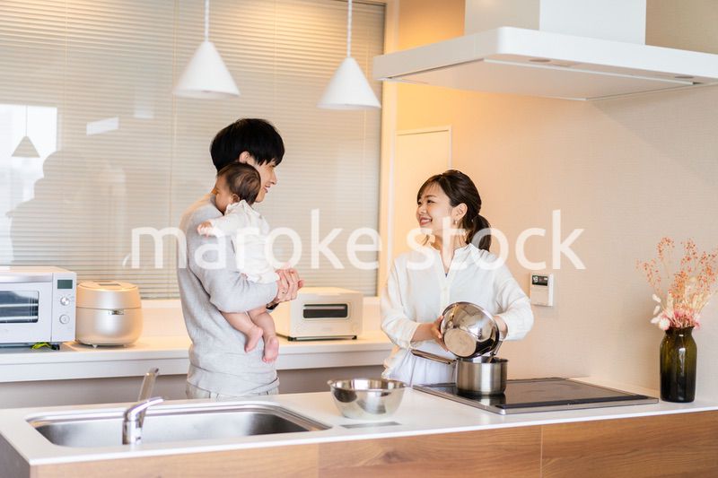 キッチンで料理をするお母さんとお父さんと赤ちゃん