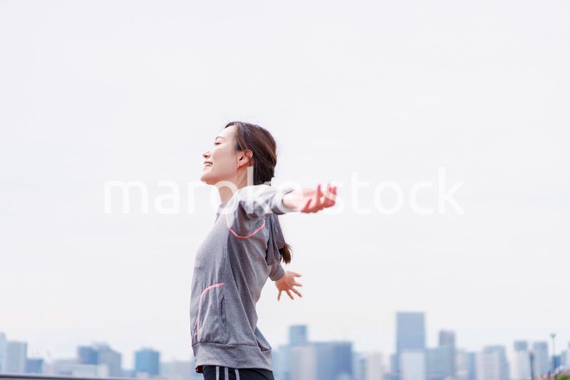 スポーツウェアで深呼吸をする若い女性