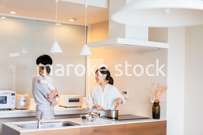 キッチンで料理をするお母さんとお父さんと赤ちゃん