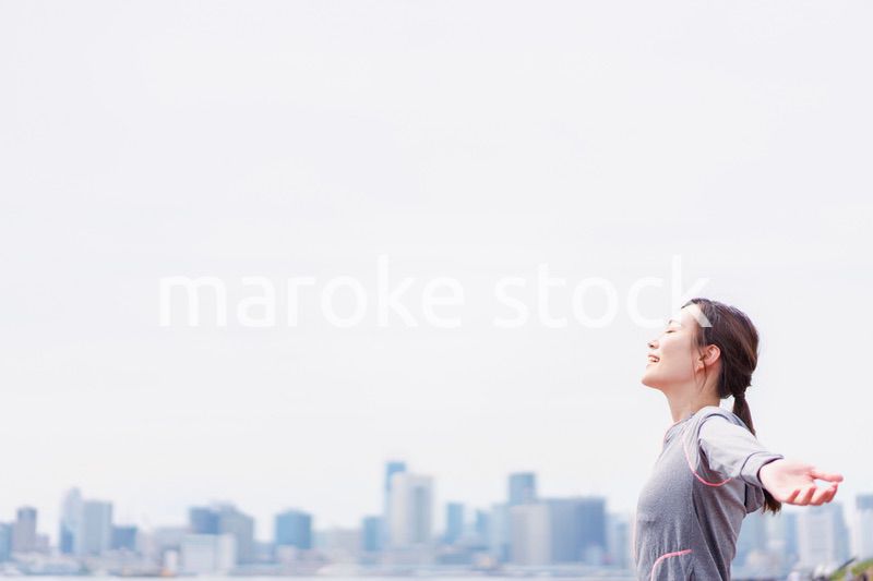 スポーツウェアで深呼吸をする若い女性